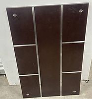 Full view of brown glass panel with metal trim and corner holes