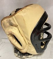 Side view of padded fencing helmet on styrofoam head