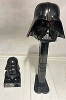 Front view of both Darth Vader items showing scale difference, PEZ dispenser and pencil sharpener