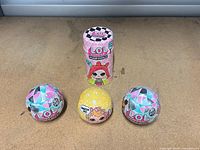 Four unopened L.O.L. Surprise packages: one Hairgoals tube, three spheres