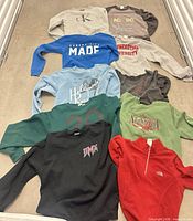 All ten sweatshirts laid out flat showing fronts