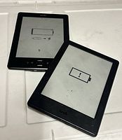 Two Kindles front view, low battery icons visible