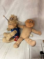 Front view of both Cabbage Patch Kids dolls showing overall condition and attire