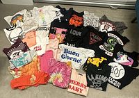 All 33 assorted women’s graphic T-shirts laid out flat showing variety of prints and colours