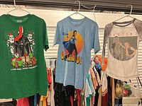 All three Star Wars T-shirts hanging: green Vader Christmas tee, blue Lando tee, grey raglan Besties tee
