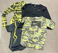 All four workout shirts laid flat showing front designs