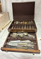 Overall view of flatware in wooden chest, open top tray and drawer visible
