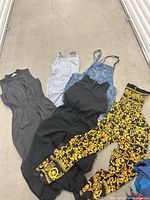 Five assorted women’s rompers laid out on floor showing overall styles and colors