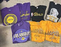 All seven Lakers and Kobe Bryant t-shirts laid out for viewing