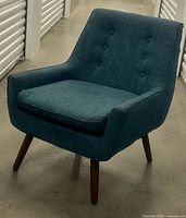 Front angle of blue tweed armchair showing seat cushion, arms, legs