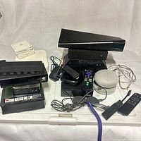 Group of streaming devices, routers, Google Home Mini, remotes and cables displayed together