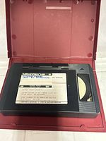 VHS tape inside red case showing production label