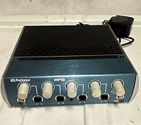 Front view of PreSonus HP4 showing four headphone level knobs, monitor level knob, four 1/4-inch headphone jacks, power adapter visible