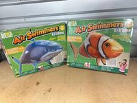 Front view of two Air Swimmers eXtreme boxes showing Great White Shark and Clown Fish versions