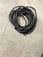Coiled black Samson instrument cable with straight 1/4-inch connectors and Velcro tie visible