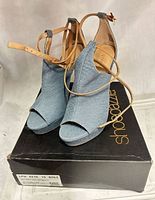 Front view of denim heels on Shoedazzle box
