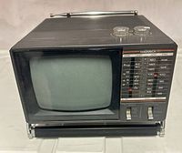 Front view of Magnavox 5-inch portable TV showing screen, controls, antenna and stand