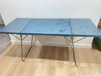 Full view of unfolded blue metal folding camp table