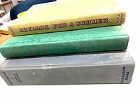 Three hardcover books stacked showing spines