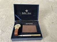 Open gift box showing watch, pen, card holder