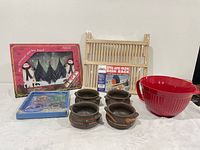 Group shot of all kitchen items: glass coasters set, packaged cutting board, folding dish rack, four ceramic bowls, red plastic mixing bowl