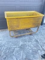 Full view of yellow plastic bin cart on casters