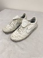 Pair of white Nike Tiempo cleats top view showing fold-over tongues and uppers