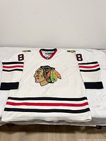 Front view of white Chicago Blackhawks Patrick Kane #88 jersey showing embroidered crest and striping