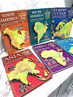 Group shot of five atlas volumes showing cover art