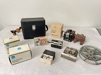 Overview of entire lot showing cameras, cases, Minolta boxes, flash unit, splicer and reel