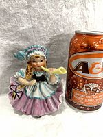 Front view of figurine beside soda can for scale