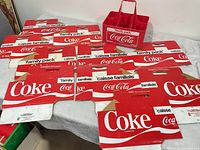 Plastic and cardboard Coca-Cola carriers spread on table