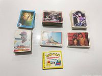 Overview of seven stacks of assorted trading cards showing variety of themes and Pac-Man card