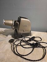Left side view of projector with power cord and lens cap displayed