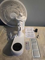 Complete fan components laid out including base, head, remote, manual, hardware