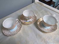 Three teacup and saucer sets showing overall pattern and number of pieces