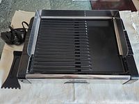 Grill/griddle with probe cord and scraper tool displayed