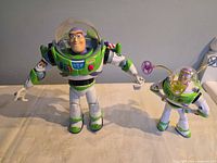 Front view of both Buzz Lightyear figures standing upright