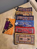 Nine fabric pouches laid out on table, showing prints and embroidery