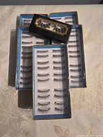 Five boxes of false eyelashes, four large trays and one small box