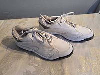 Side view of both FootJoy white golf shoes