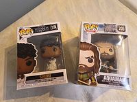 Front view of both boxed Funko Pop figures: Shuri #1174 and Aquaman #205