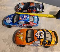 Top view of all three NASCAR cars with tape measure for scale
