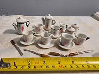All porcelain tea pieces with ruler and two knives for scale