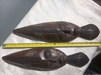 Top view of both wooden masks with measuring tape showing length