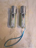 Pair of flashlights front view showing LED strips and wrist strap