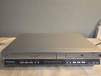 Front view showing DVD and VHS slots, control buttons, overall casing condition