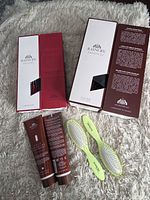 Two boxed Raincry natural bristle brushes, two leave-in treatment tubes, two vented brushes displayed