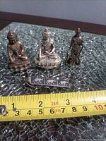 overview of three figurines and elephant clip with tape for scale