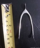 Tongs beside tape measure showing 8 cm length